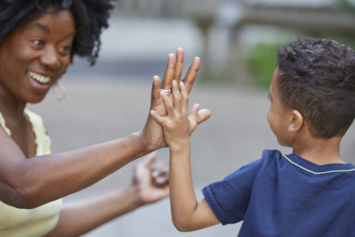 Woman high fiving a child