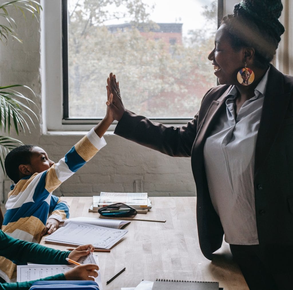 Teacher high fiving a child