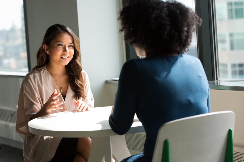 Two women sat at a table, talking