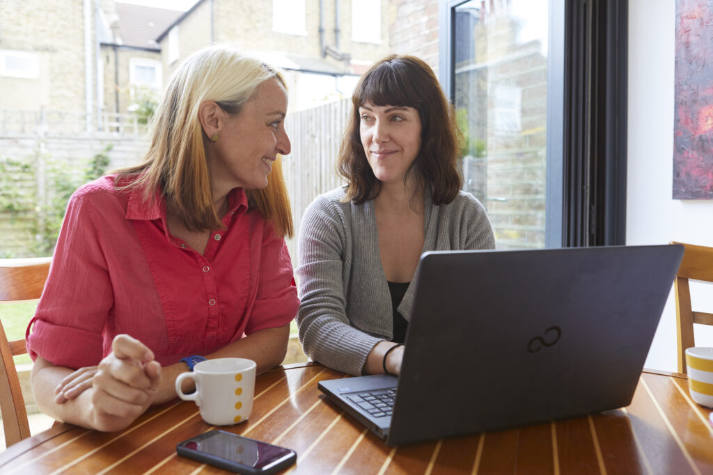 Two women sat at a laptop